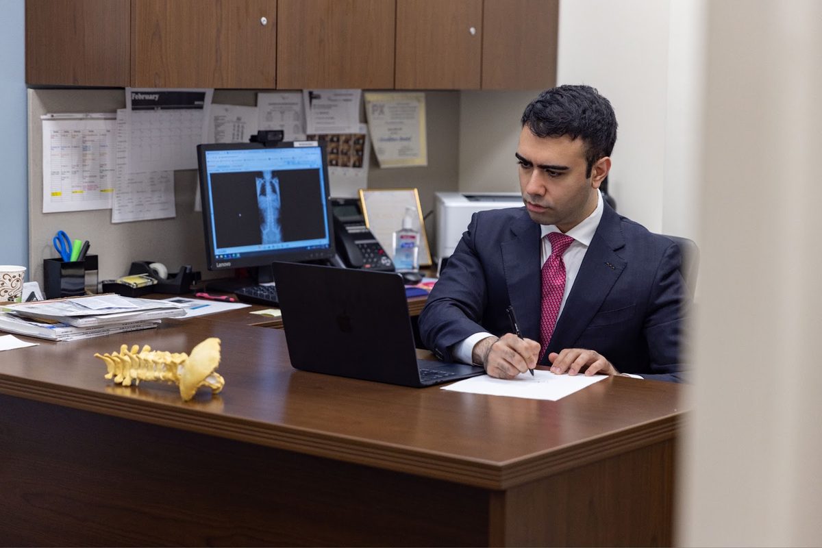 Dr. Rasouli reviewing spine imaging in his office